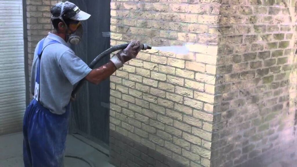 Gevel stoomreiniging 1 gevelreiniger die gevel stoomreiniging uitvoert om de buitenmuur schoon te maken.